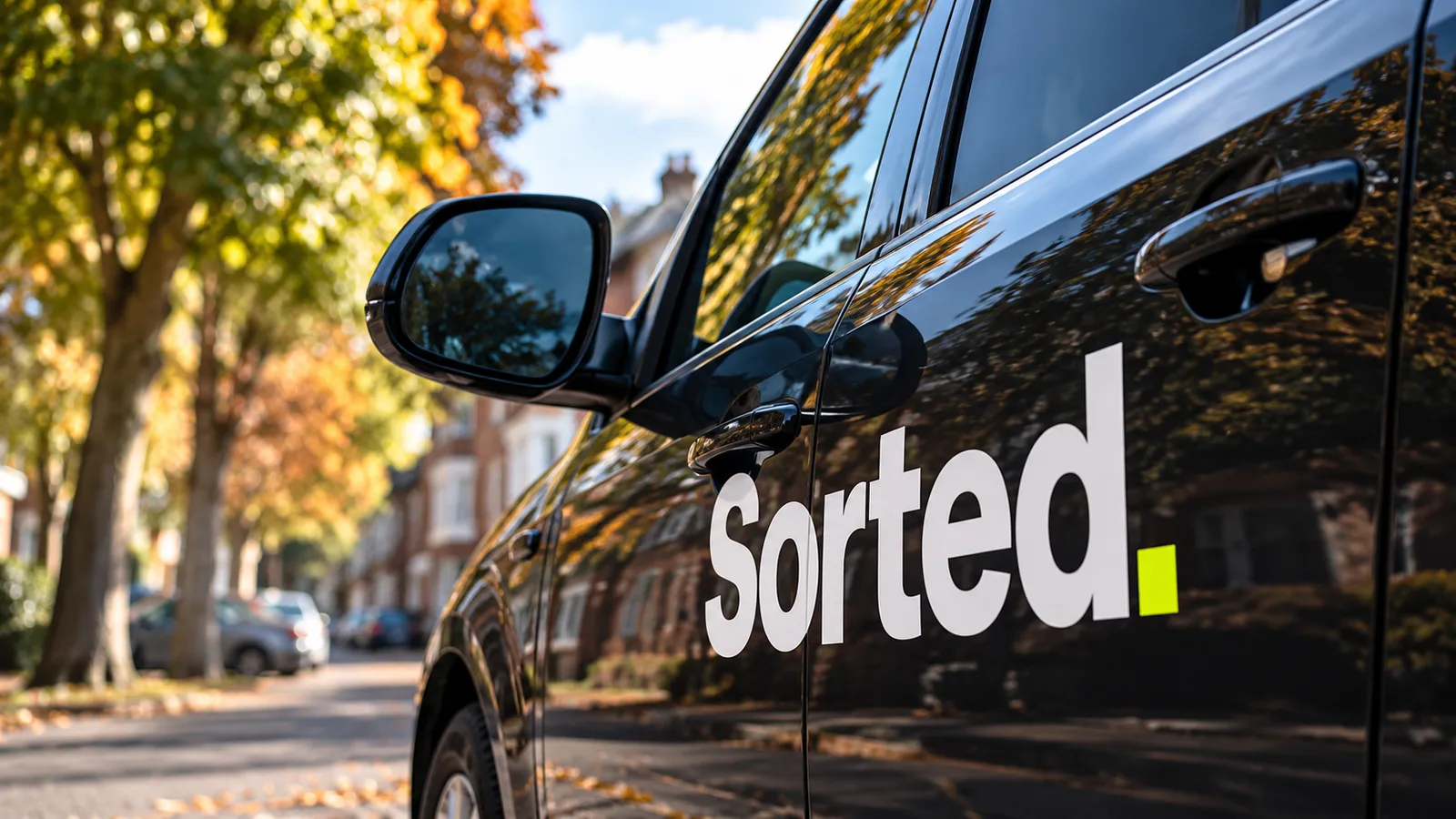 A Sorted sign-written van on an autumn street — brand concept